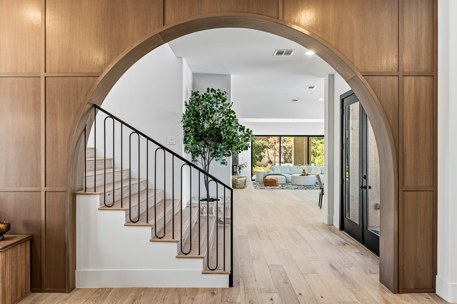 Wood-panelled arched entry opening onto the staircase and living room