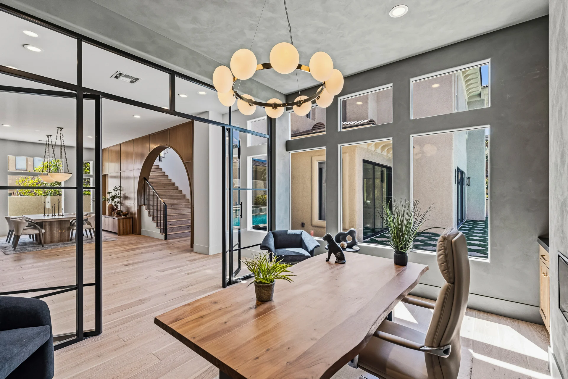 Private office behind steel-framed glass with views to the courtyard
